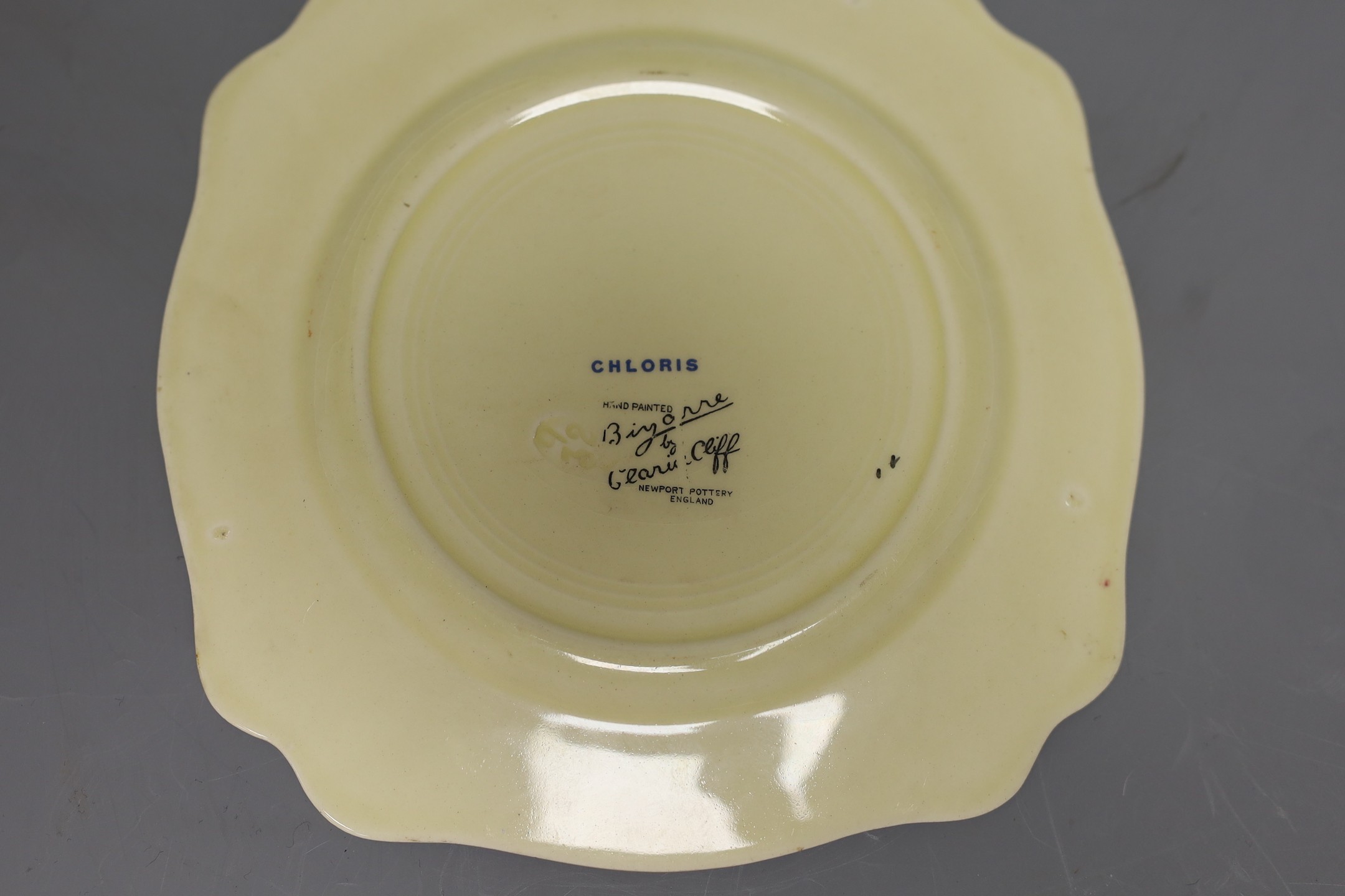 A Clarice Cliff crocus design milk jug and a Bizarre patterned side plate, jug 11.5 cms high